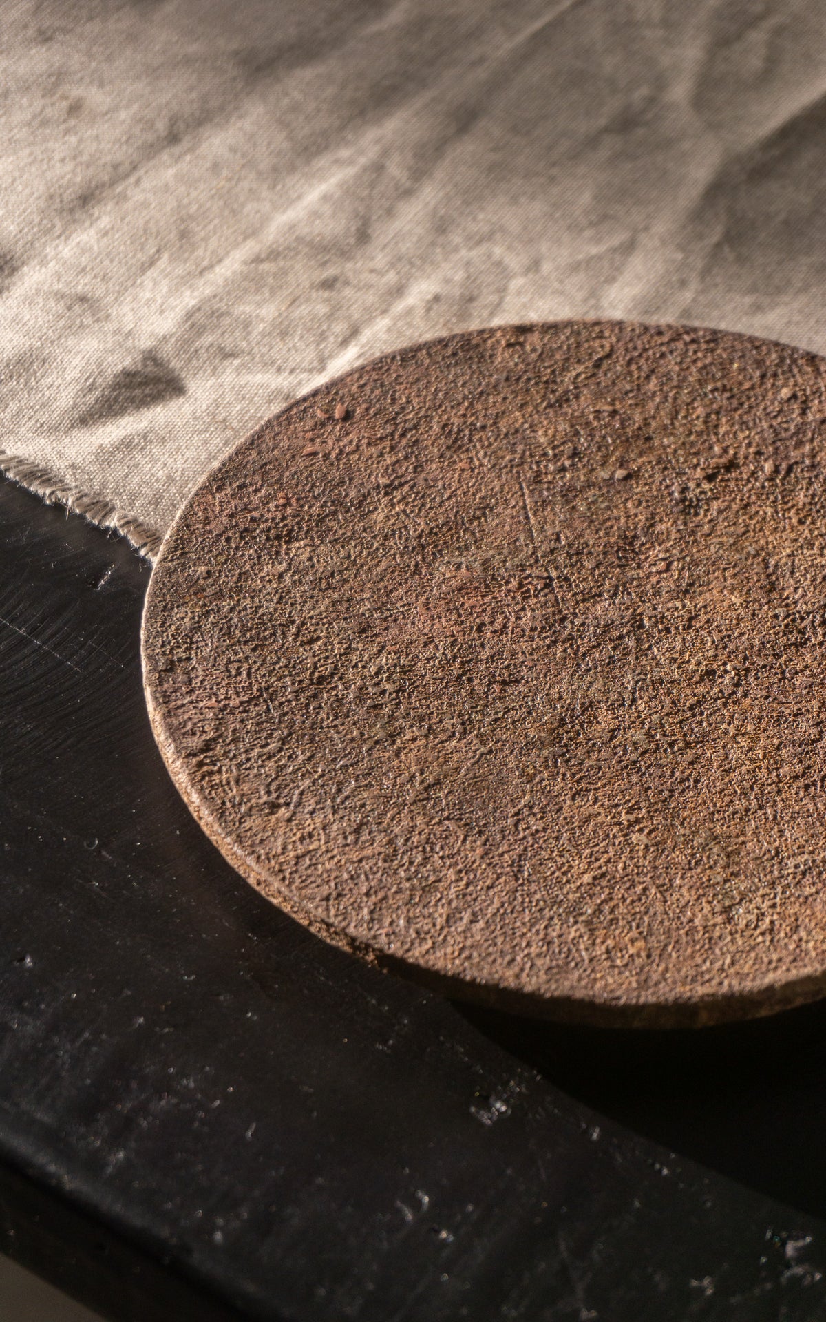 Round dark brown ceramic plate on a wooden surface