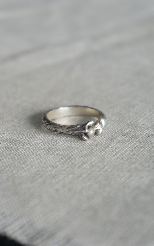 Silver patina bone ring on a gray textured surface