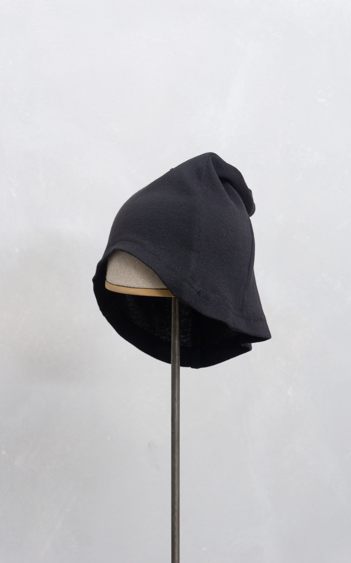 Black beanie on a mannequin head against a white background